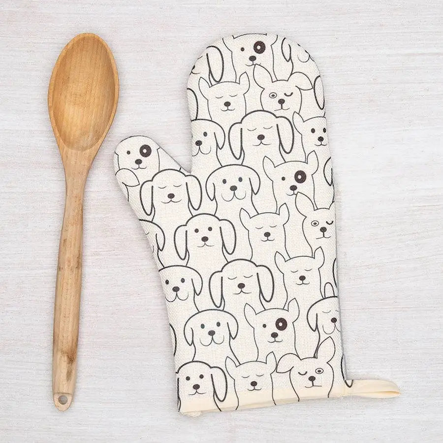 Oven mitt with dog pattern and wooden spoon on a light background