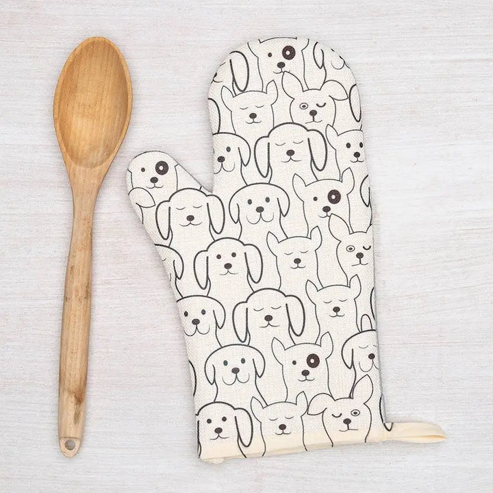 Oven mitt with dog pattern and wooden spoon on a light background
