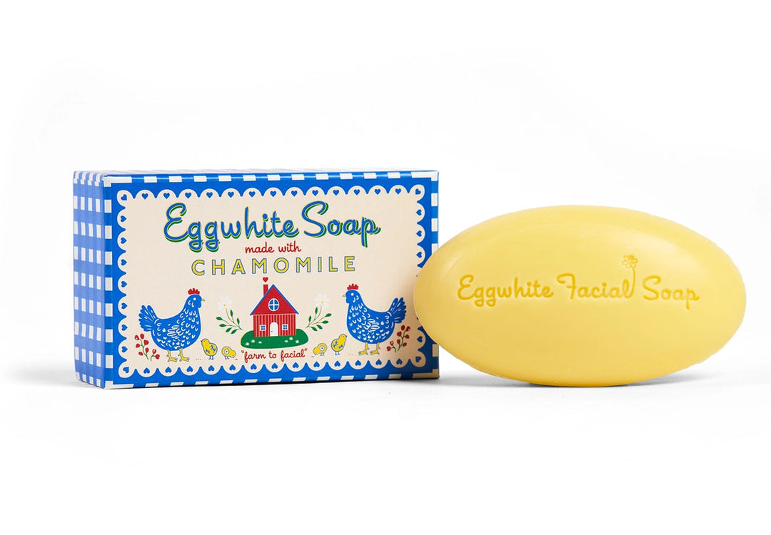 A yellow oval bar of Eggwhite Facial Soap next to its blue and cream packaging box, set against a plain white background.