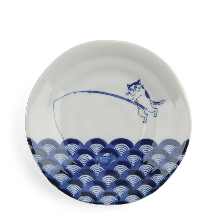 White plate with blue wave pattern and cat illustration on a white background