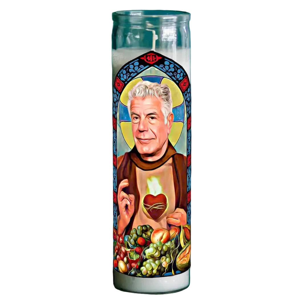 Candle with a religious-style depiction of a person holding a heart and fruits on a dark background