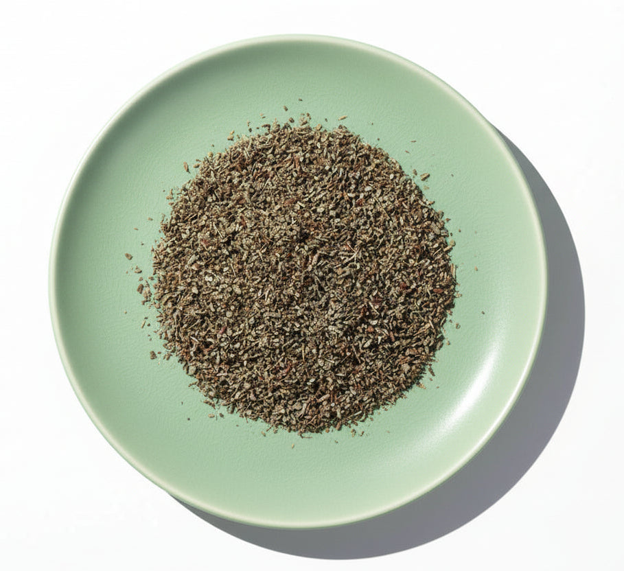 Dry herb mix on a white plate with a white background